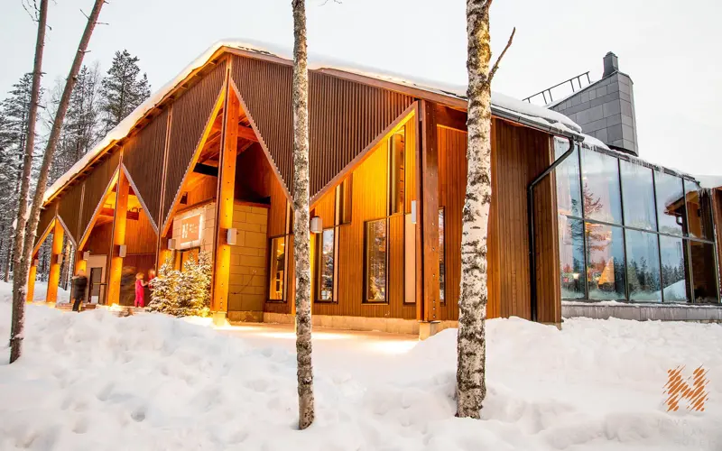 The modern wood and glass exterior of the main reception and restaurant building at Nova Skyland Hotel next to Santa Claus Village in Rovaniemi, Finnish Lapland