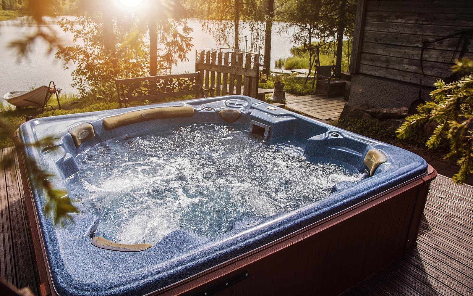 A large bubbling jacuzzi sits on the wooden deck overlooking the lake at Iisakki Village near Ruka in Finland