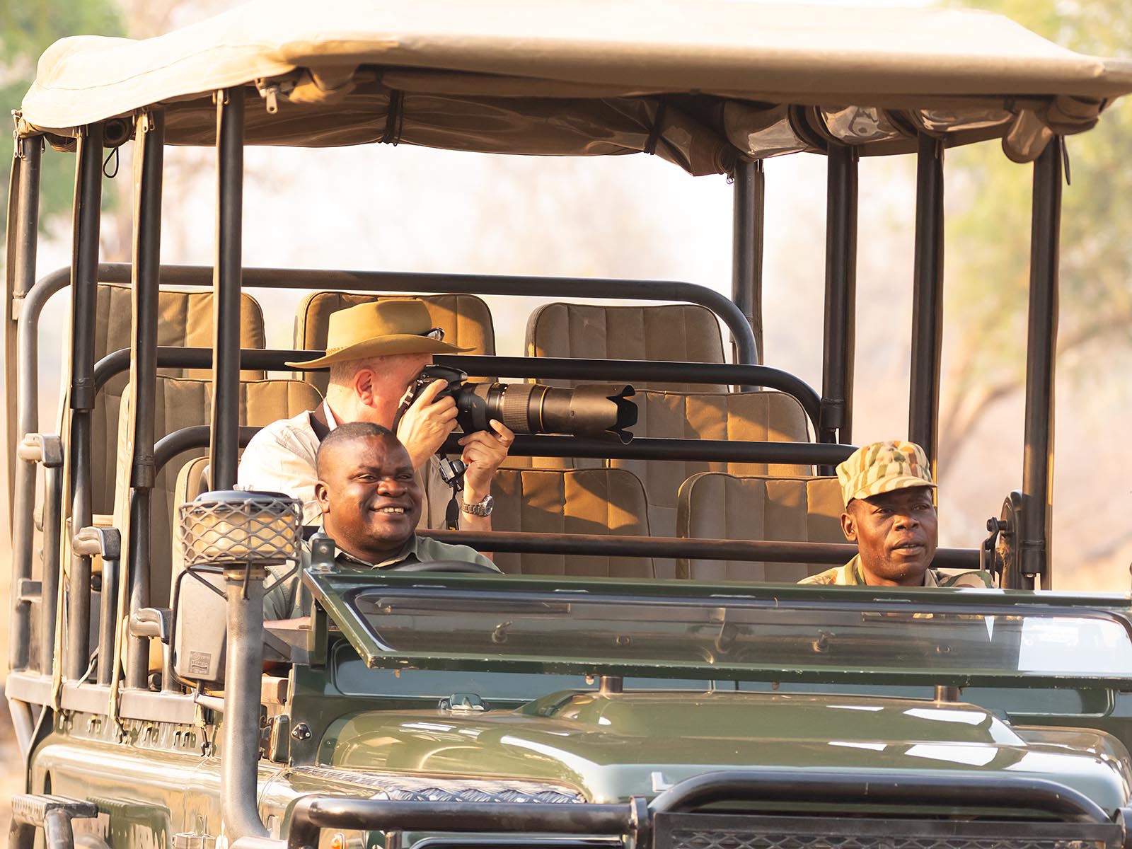 Photographer and guides in a safari vehicle in Zambia