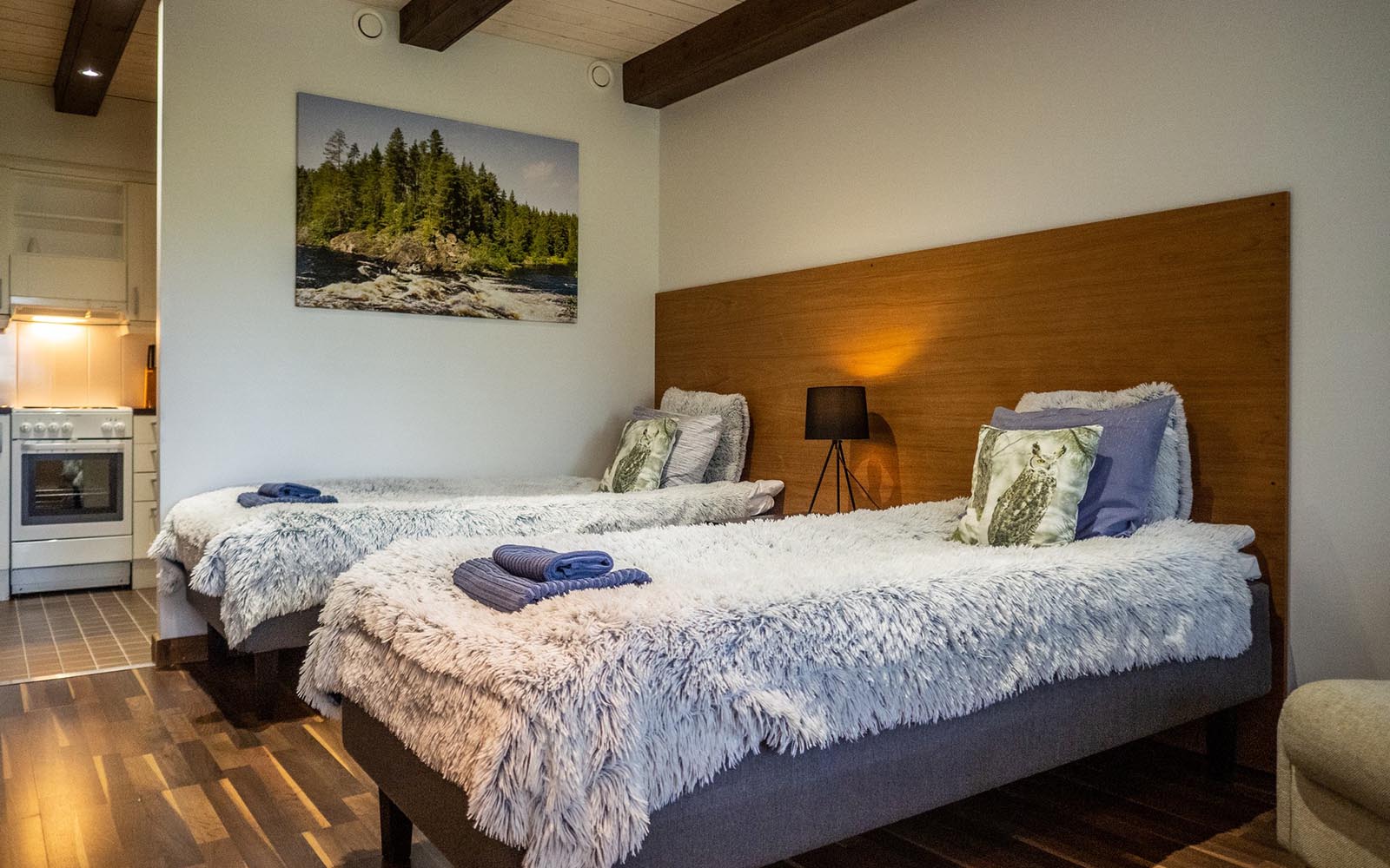 Twin beds with fluffy blankets in a guest room at Wilderness Hotel Papin Talo, Iisakki Village, near Ruka, Finland