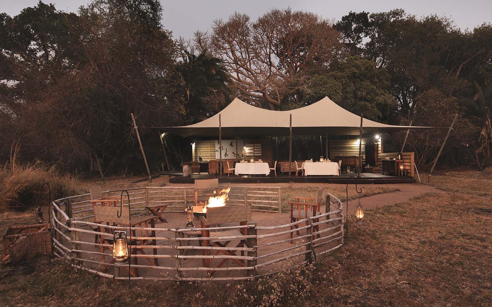 View towards the lounge area and bar from the open firepit at Busanga Bush Camp, Kafue, Zambia