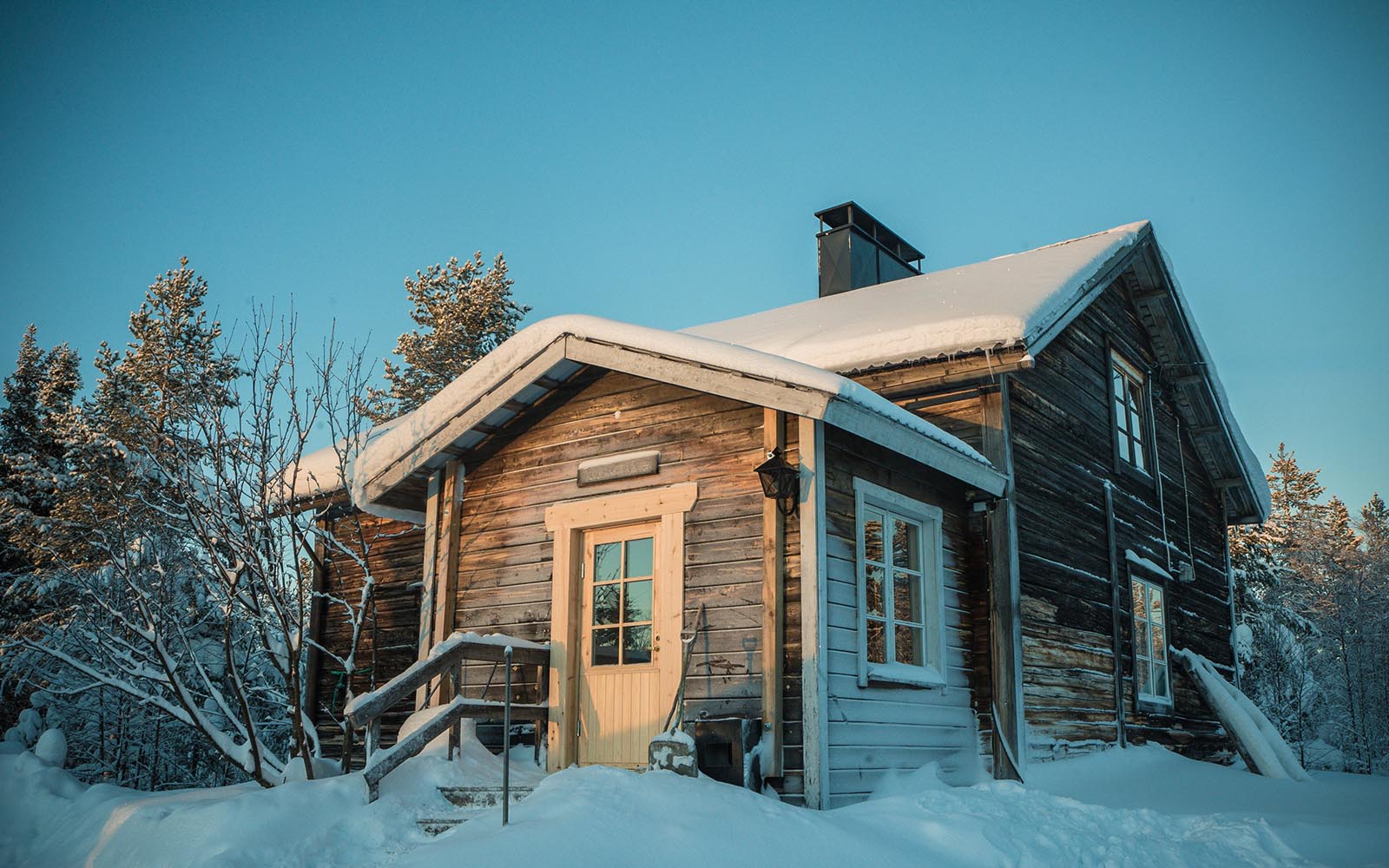This snow covered wilderness log cabin in a idyllic winter setting is used for overnight safaris in Finnish Lapland 