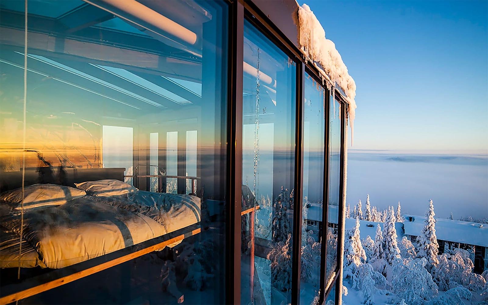 looking inside the Eagle View Suite though the glass façade you can see the circular bed along with far reaching views to the snow covered valley below