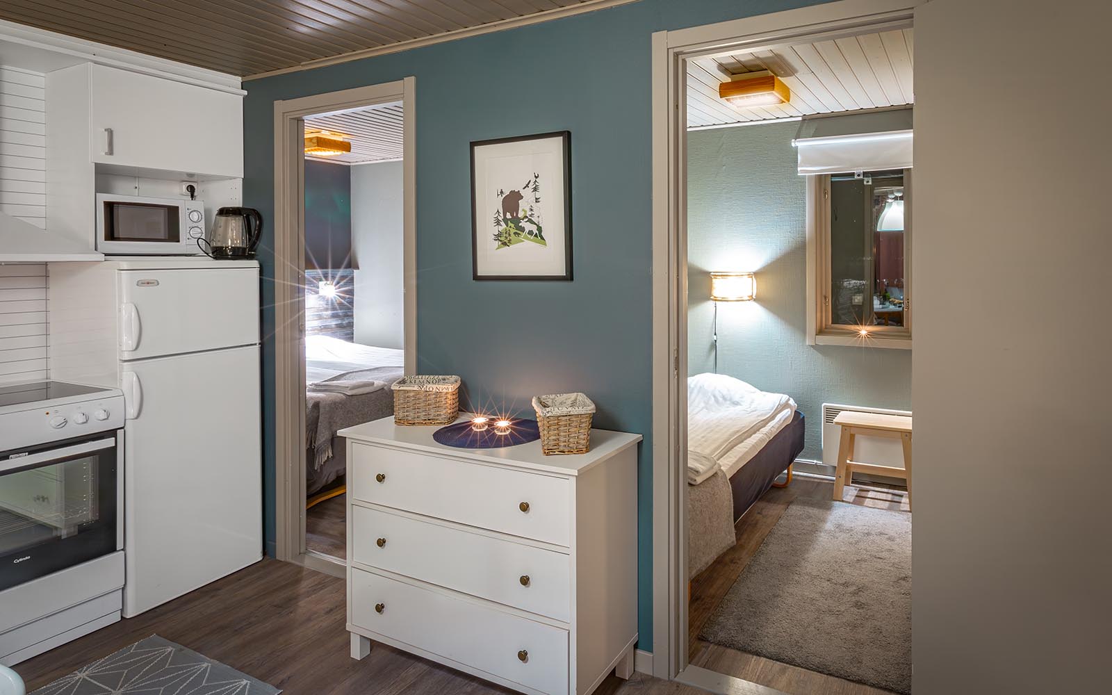 The lounge area of the cabins Brandon Lodge with kitchenette leads directly into the two bedrooms, perfect for families to holiday in Swedish Lapland.