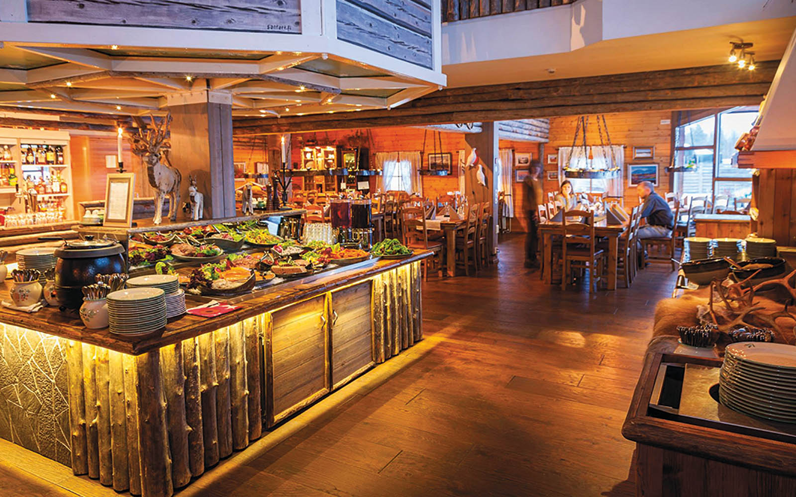 Buffet dinner table laid out with plates full of food in Humina Ravintolana, the main restaurant at Hotel Yllas Humina in Lapland, Finland
