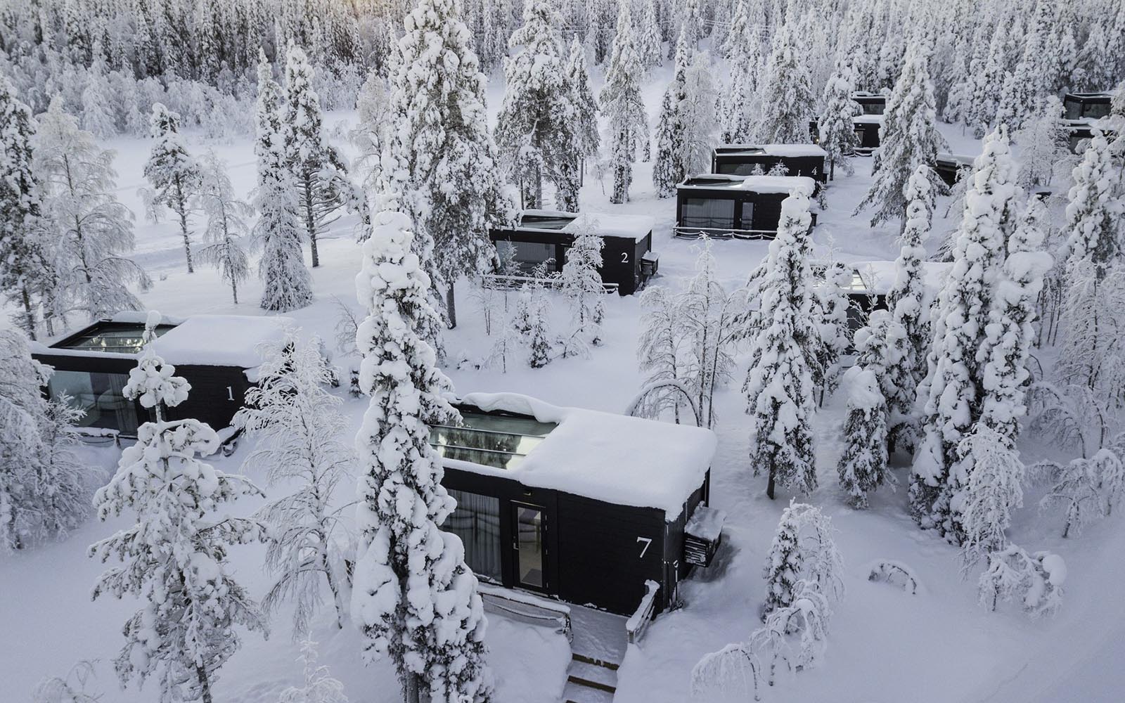 This aerial shot of the Aurora Glass Villas surround by trees at Iisakki Glass Village in Finnish Lapland shows where the heated glass roof has melted the snow
