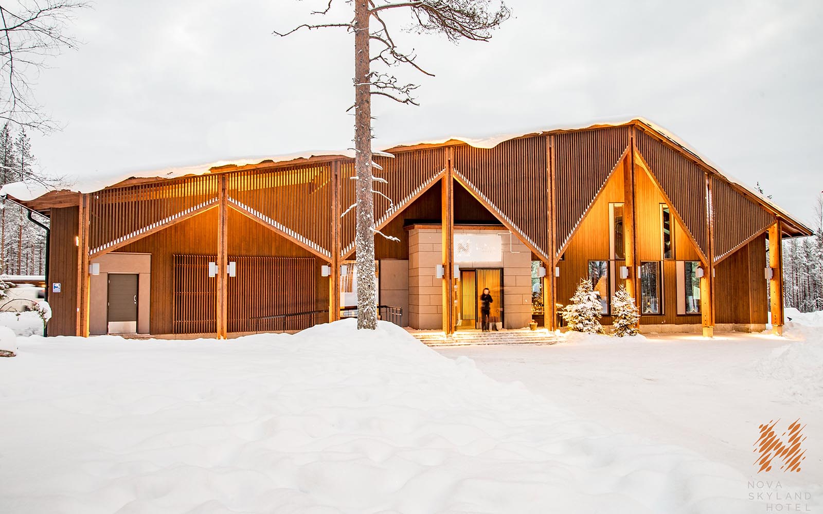 Looking across the snowy landscape towards the main entrance of Nova Skyland Hotel next to Santa Claus Village in Rovaniemi, Finnish Lapland 