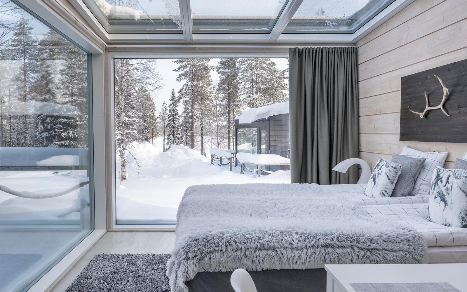 The double aspect corner window and glass ceiling of the Glass Villas at Iisakki Glass Village offers fantastic views to the winter wonderland outside