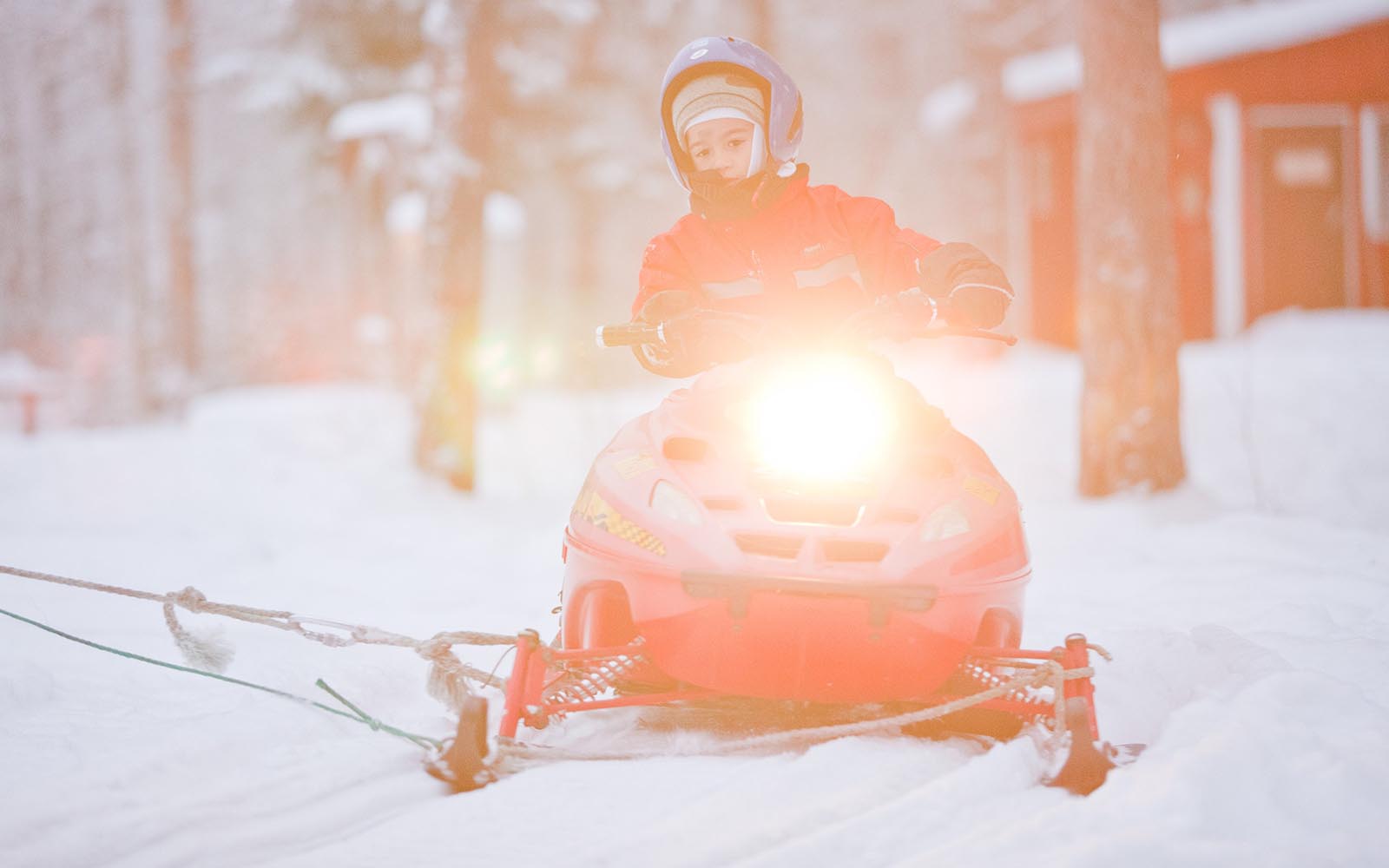 A child rides a mini snowmobile during an activity day at Harriniva Adventure Resort in Finland