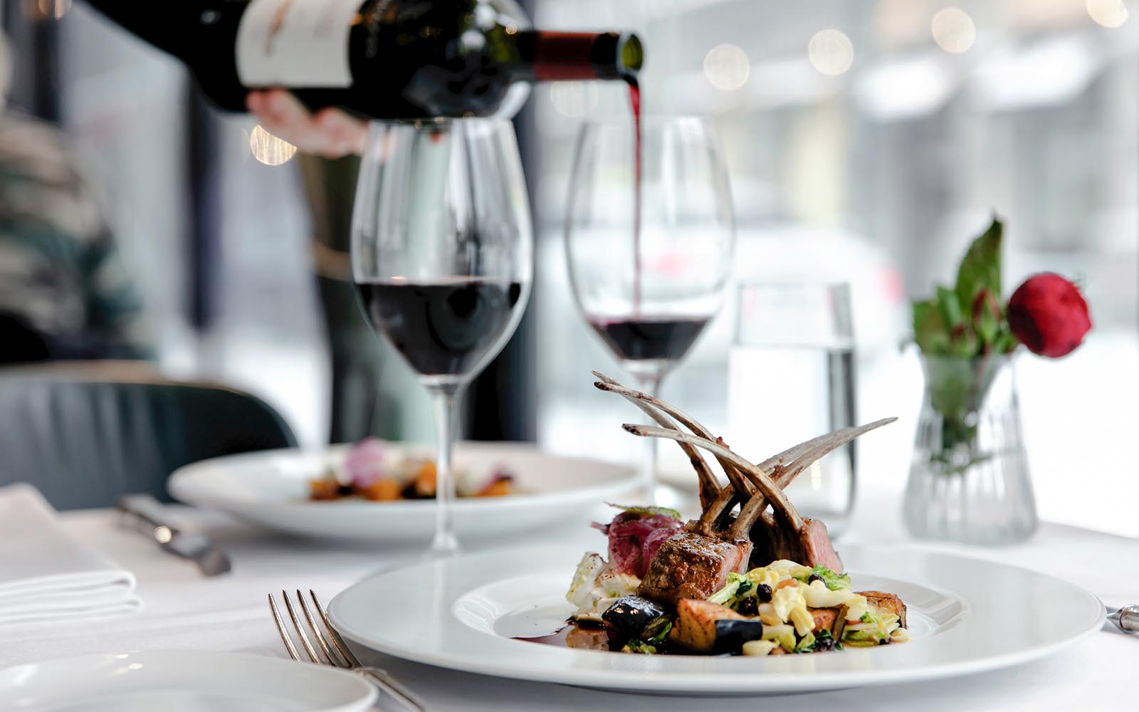 A rack of lamb is served and red wine poured at Notes by Kämp, a stylish and relaxed restaurant in Helsinki, Finland